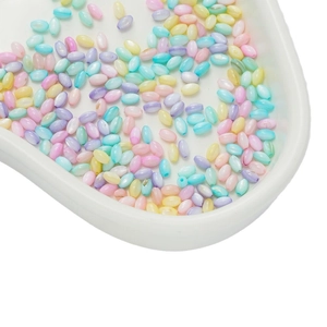 Mix of macaron colored rice beads in a white tray for DIY jewelry and crafts
