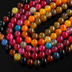 Macro shot of colorful dragon vein agate beads with crackle texture on black background
