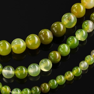 Macro detail of dragon vein green agate beads with natural ice crack texture on black mirror