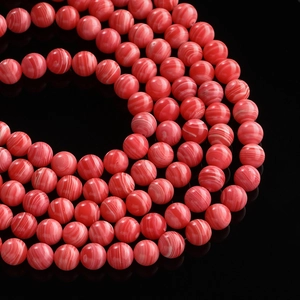 Macro shot of red synthetic silk agate beads with natural white spiral patterns for DIY jewelry