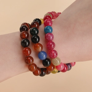 Three assorted dragon vein agate bead bracelets featuring natural gemstone textures