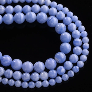 Macro shot of blue striped agate loose beads with natural white band patterns on black surface