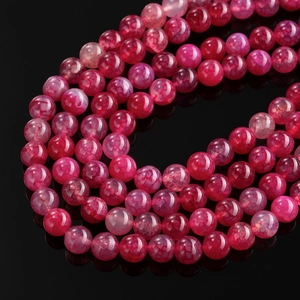 Detailed macro view of spiral wound red dragon vein agate beads with high luster on black
