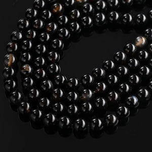 Macro detail of polished black dragon vein agate beads with unique crackle texture