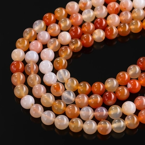 Macro view of polished dragon vein agate beads with cracked texture in red and orange