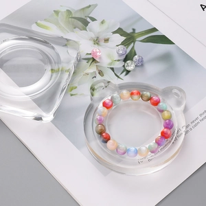 Nahaufnahme von Perlenarmband mit bärförmigem Acryl-Display auf ästhetischem Hintergrund