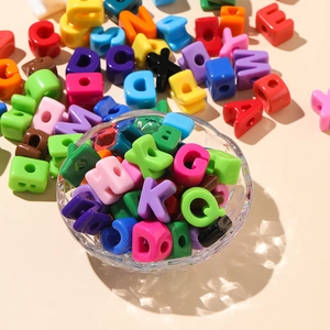 Macro shot of colorful acrylic alphabet beads in a glass bowl for DIY jewelry