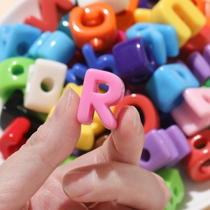 Macro shot of colorful acrylic alphabet beads for DIY jewelry with a focus on letter R
