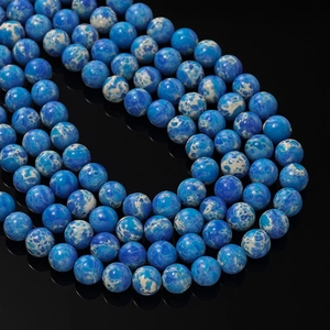 Makroansicht blauer Kaiserstein-Rundperlen für DIY-Schmuck mit weißer Marmortextur