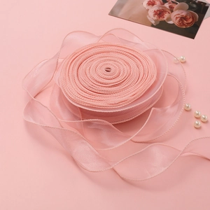 Detailopname van roze organza fishtail lint met fijne randen voor DIY cadeauverpakkingen