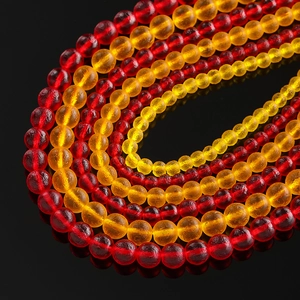 Macro shot of 6mm to 10mm round glass moldavite style beads with amber and deep red tones