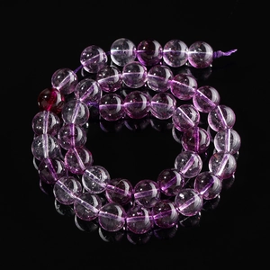 Macro detail of round purple ghost crystal beads showing natural texture and transparency