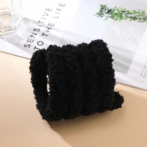 Close-up of black 2cm thick plush chenille stem with dense curly coral fleece texture