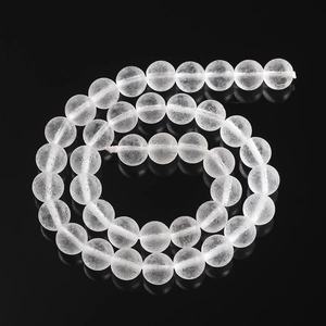 Macro detail of frosted white glass beads with internal ice crack texture on black background