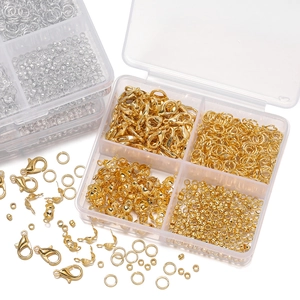 Close-up of golden lobster clasps and jump rings in a multi-grid storage box