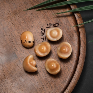 Brown amber-like sycee shaped beads for DIY jewelry making in a wooden tray