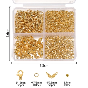 Detailed view of golden lobster clasps, jump rings and crimp beads in a plastic storage box