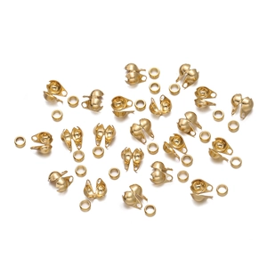 Detailed macro view of gold-plated stainless steel ball crimp covers for DIY jewelry