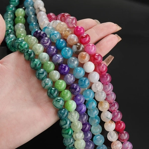 Gekleurde drakenader agaat ronde kralen voor DIY sieraden maken in de hand gepresenteerd