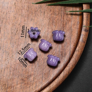 Purple tulip shaped bead for jewelry making with dimension markers on wooden tray
