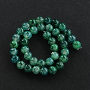 Macro-opname van groene agaatkralen met natuurlijke drakenadertextuur voor DIY-sieraden
