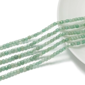 Vista dettagliata di perle a cubo da 3mm in avventurina verde sfaccettata su un vassoio