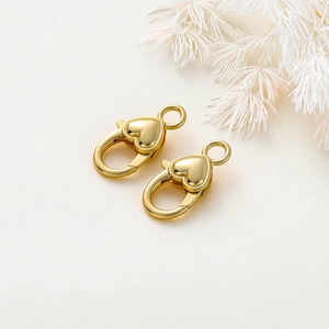 Dettaglio di due chiusure a moschettone a forma di cuore placcate oro 18k per gioielli