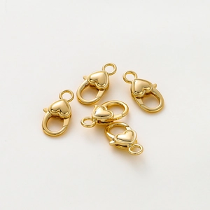 Dettaglio di cinque moschettoni a forma di cuore placcati in oro 18k per gioielli fai-da-te