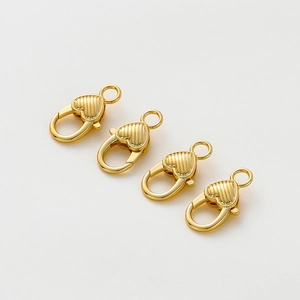 Vista macro di chiusure a moschettone a cuore in oro 14K con strisce verticali per gioielli
