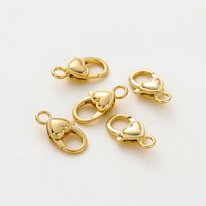 Dettaglio di cinque chiusure a moschettone a cuore placcate oro 18k per creazione gioielli