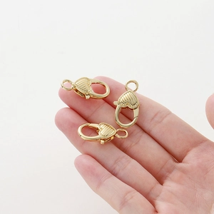 Dettaglio dei fermagli a moschettone a cuore placcati oro 14K per creazione gioielli