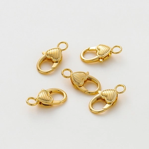 Dettaglio macro di moschettoni a cuore placcati oro 14K con elegante texture rigata