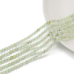 Dettaglio di perle sfaccettate in pietra naturale verde chiaro su un piatto bianco