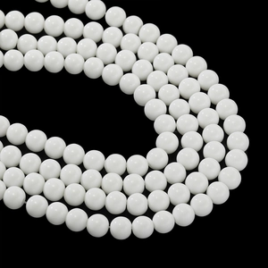 Polished white ceramic beads for DIY jewelry making in multiple sizes on black background
