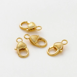 Vista macro di chiusure a moschettone a cuore placcate oro 14K con trama a righe per DIY