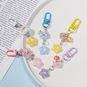 Detailed close-up of colorful resin star and cloud keychains on a white ceramic plate