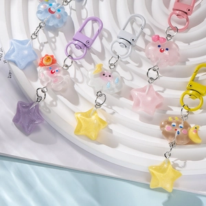 Cute resin star and cloud keychains in pastel colors on white round display stands