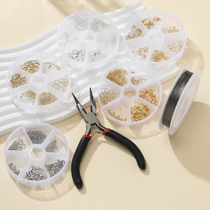 Macro shot of jewelry making kit with pliers, lobster clasps and beads in clear boxes
