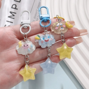 Detailed view of translucent resin star and cloud keychains with glitter and colorful clips