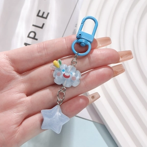 Close-up of sky blue resin star and cloud keychain with shimmering glitters