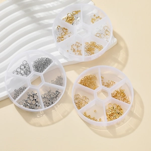 Macro view of partitioned storage boxes containing gold and silver DIY jewelry findings