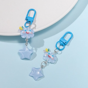 Detail of light blue resin star and cloud charms on metal lobster clasp keychains