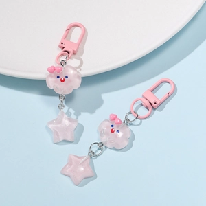 Close-up of translucent pink resin cloud and star keychains with cute face and glitter