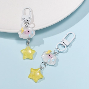 Macro detail of resin cloud and glittery star charms on a white ceramic plate