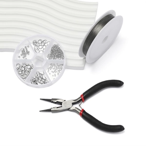 Detailed DIY jewelry making kit with silver findings, pliers, and wire on a white background