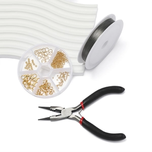 Macro view of jewelry making kit with gold clasps, beading wire, and professional pliers