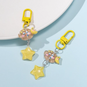 Detail of coffee resin cloud and yellow glitter star charms on yellow metal keychains