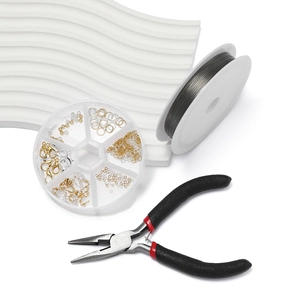 Macro view of DIY jewelry kit with steel wire, needle nose pliers, and gold findings