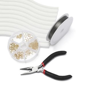 Macro shot of gold jewelry findings set with pliers and metal wire on white background