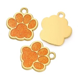 Détail de pendentifs patte dorés avec incrustation de paillettes orange et anneaux
